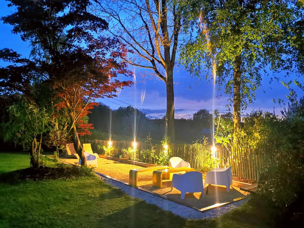 a group of chairs and tables in a yard at night at Archipel Holiday Cottage in Ellezelles