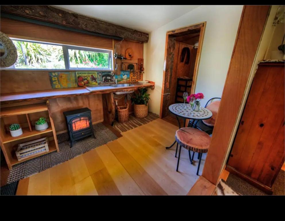 a kitchen with a fireplace and a table and a stove at Edens retreat in Upper Moutere