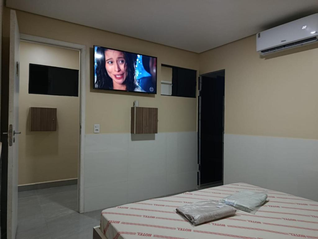 a bedroom with a bed with a tv on the wall at Hotel cowboy Interlagos próximo do autódromo e transamérica Expo Center in São Paulo