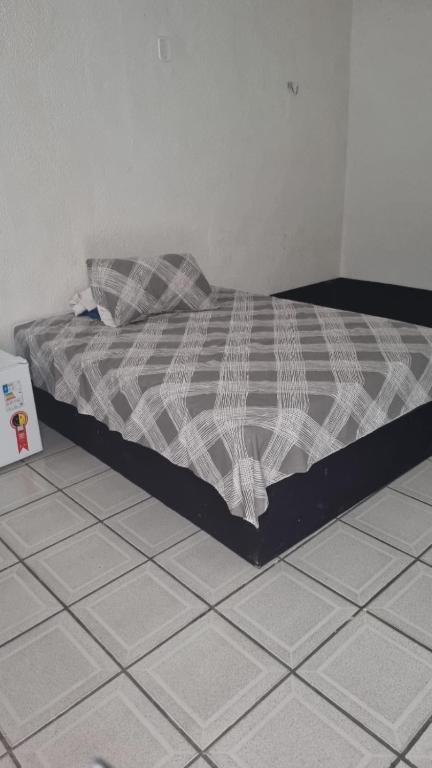 a bed sitting on a tiled floor in a bedroom at Flat da Luz in Guarabira