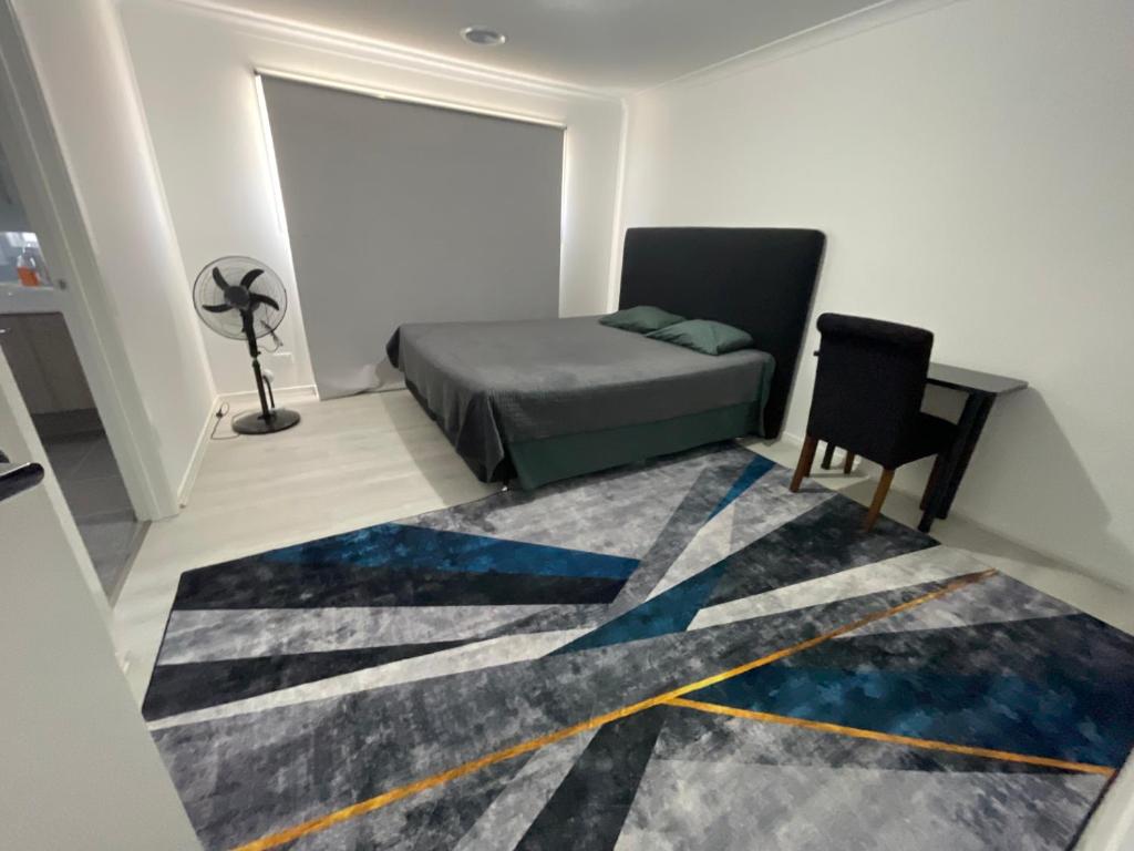 a bedroom with a bed and a desk and a rug at Ensuite room in Mount Duneed in Mount Duneed