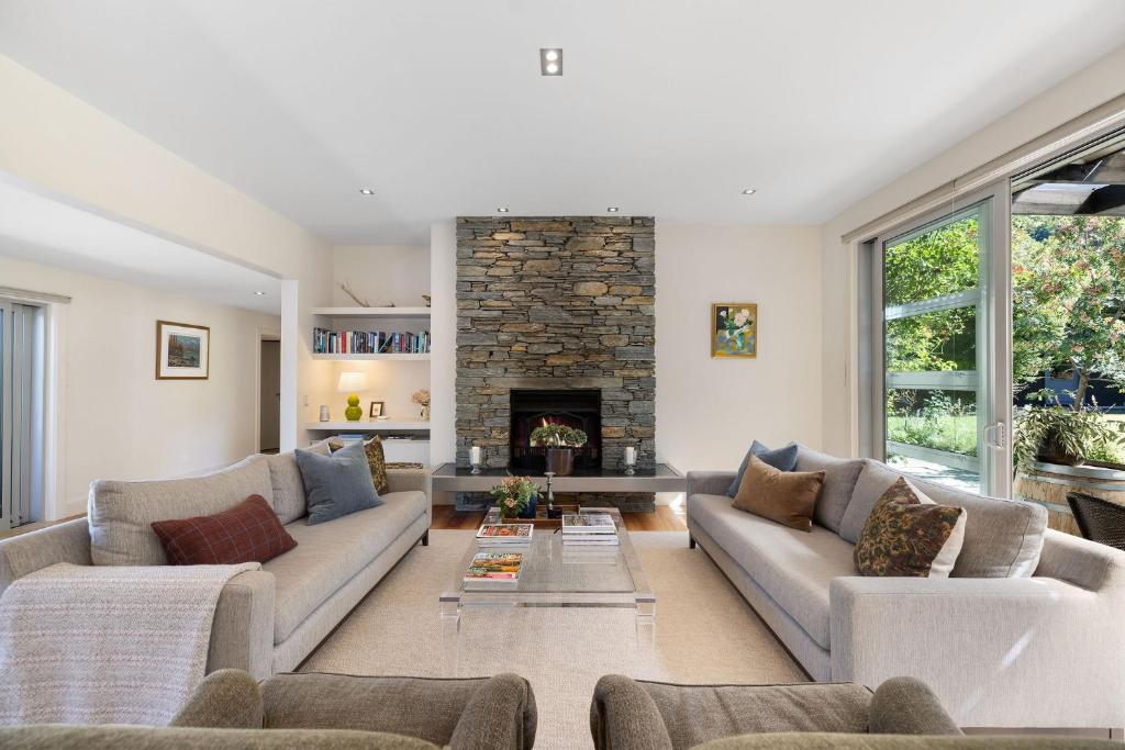a living room with two couches and a fireplace at Arrowtown Home near Golf, Biking & Walking Trails in Arrowtown