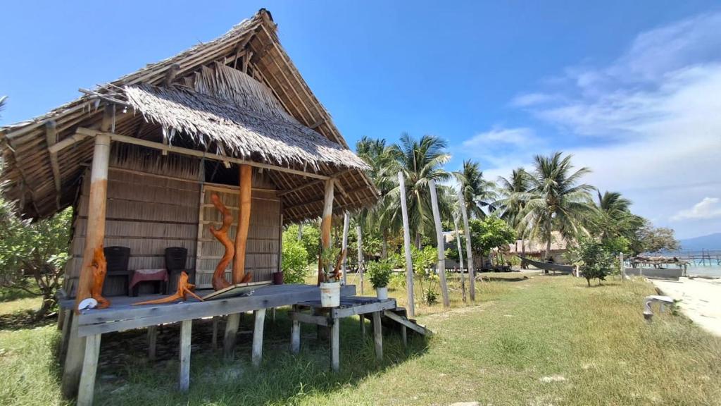 a hut with a bench in front of a beach at Yefkabu Homestay in Jef Tsiep