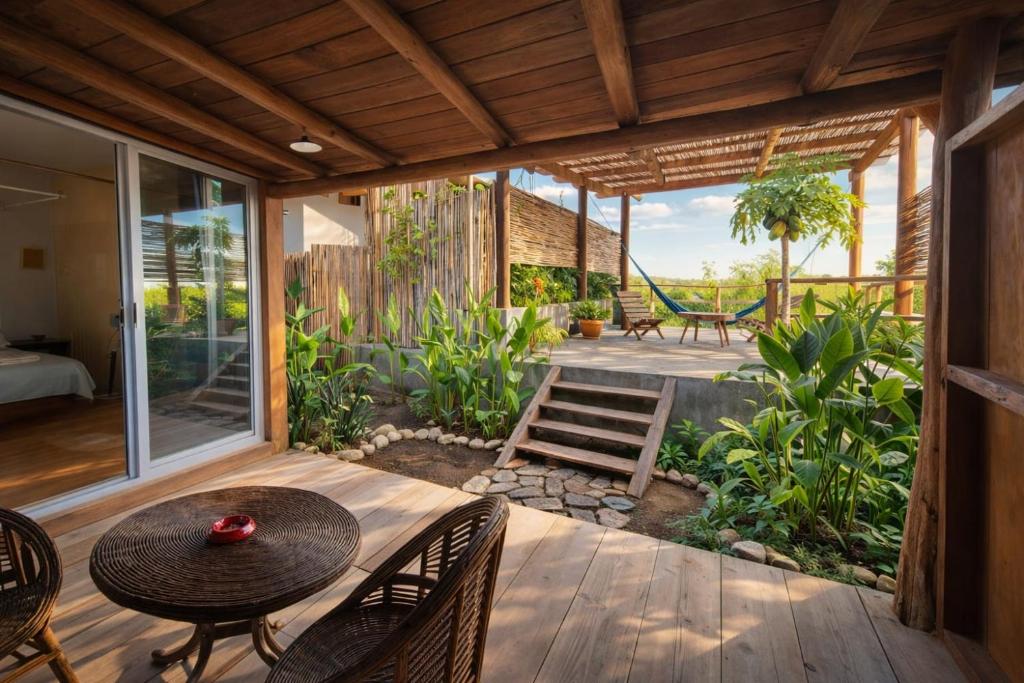 eine Terrasse mit Tisch, Stühlen und Schaukel in der Unterkunft Luna 6 in Mazunte