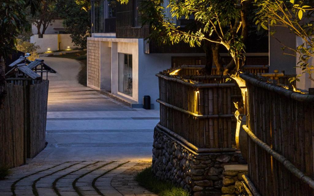 a tree in a planter next to a building with lights at CongLinLi Wooded Homestay in Conghua