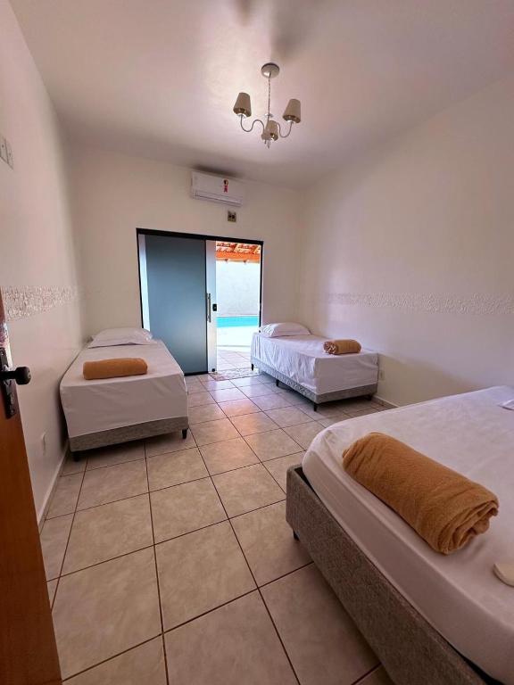a bedroom with two beds and a door to the ocean at Pousada luz do Sol in Cacoal