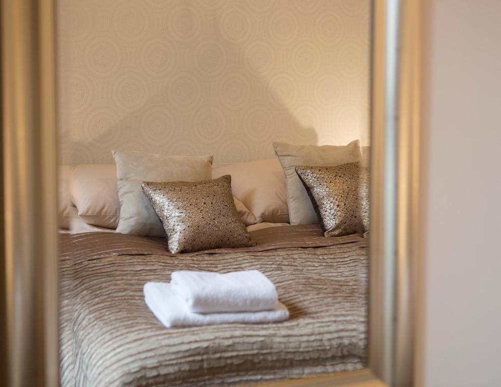 lustrzane odbicie łóżka z dwoma ręcznikami w obiekcie Apartament Bridge we Wrocławiu
