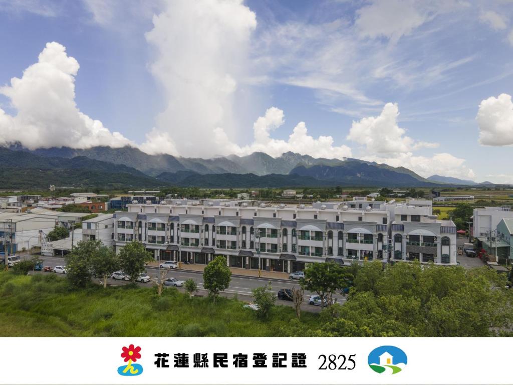 a large white building with mountains in the background at InYuLi在玉里民宿 花蓮縣民宿2825號 in Yuli