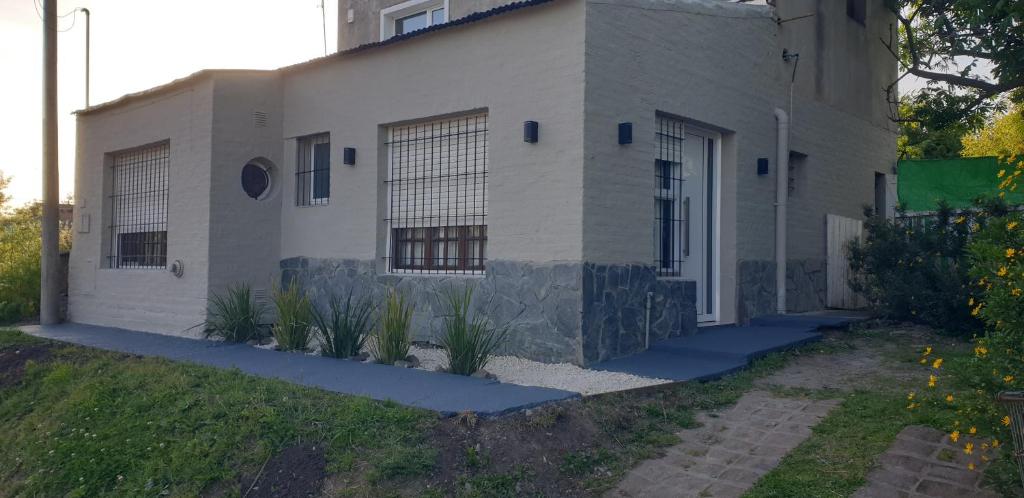 a white house with plants in front of it at Mini Loft in Tandil