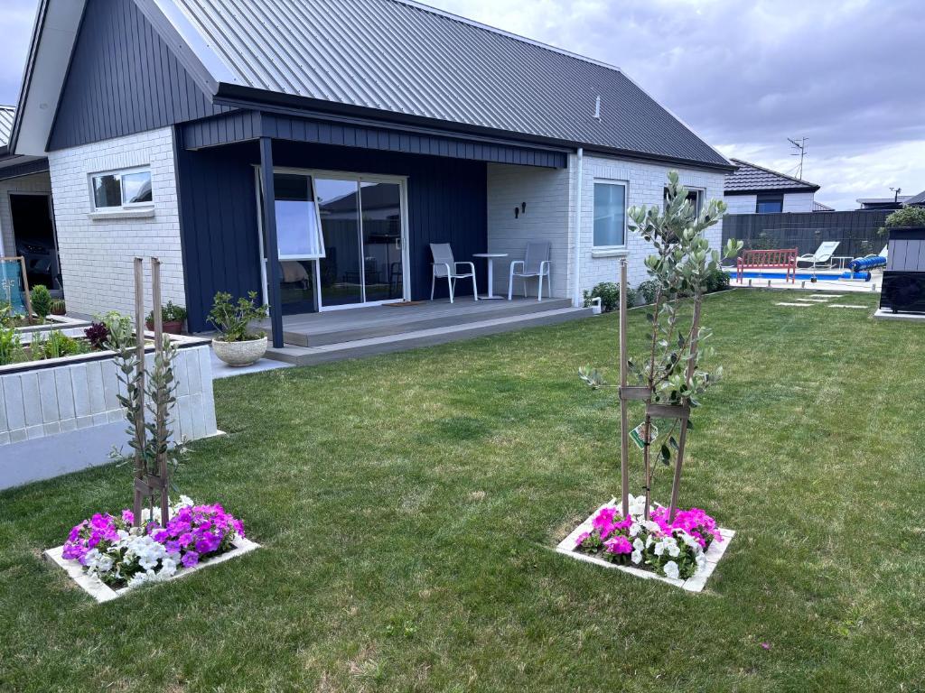 two small trees in a yard with flowers at Bestern on Mohaka in Napier