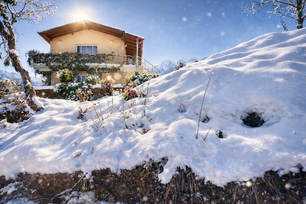 a house on a hill covered in snow at Buransh Retreat in Jageshwar