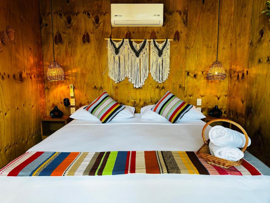 a bedroom with a white bed with wooden walls at Suites Costa Madéro - Punta Zicatela in Brisas de Zicatela
