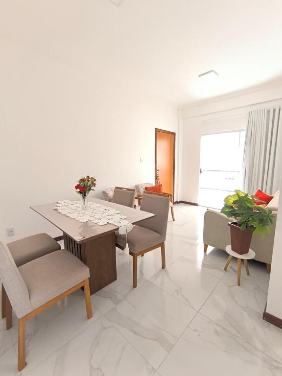 a white living room with a table and chairs at Morada Vermelha in Vitória da Conquista