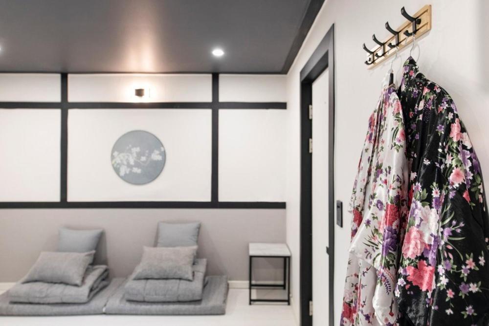 a room with two couches and a robe on a wall at Ryokan Stay in Gangneung