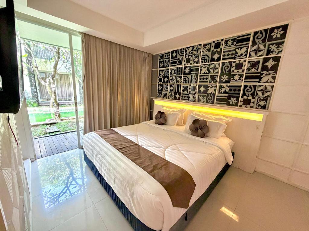a bedroom with a bed with two teddy bears on it at Dealton Hotel Sanur in Sanur