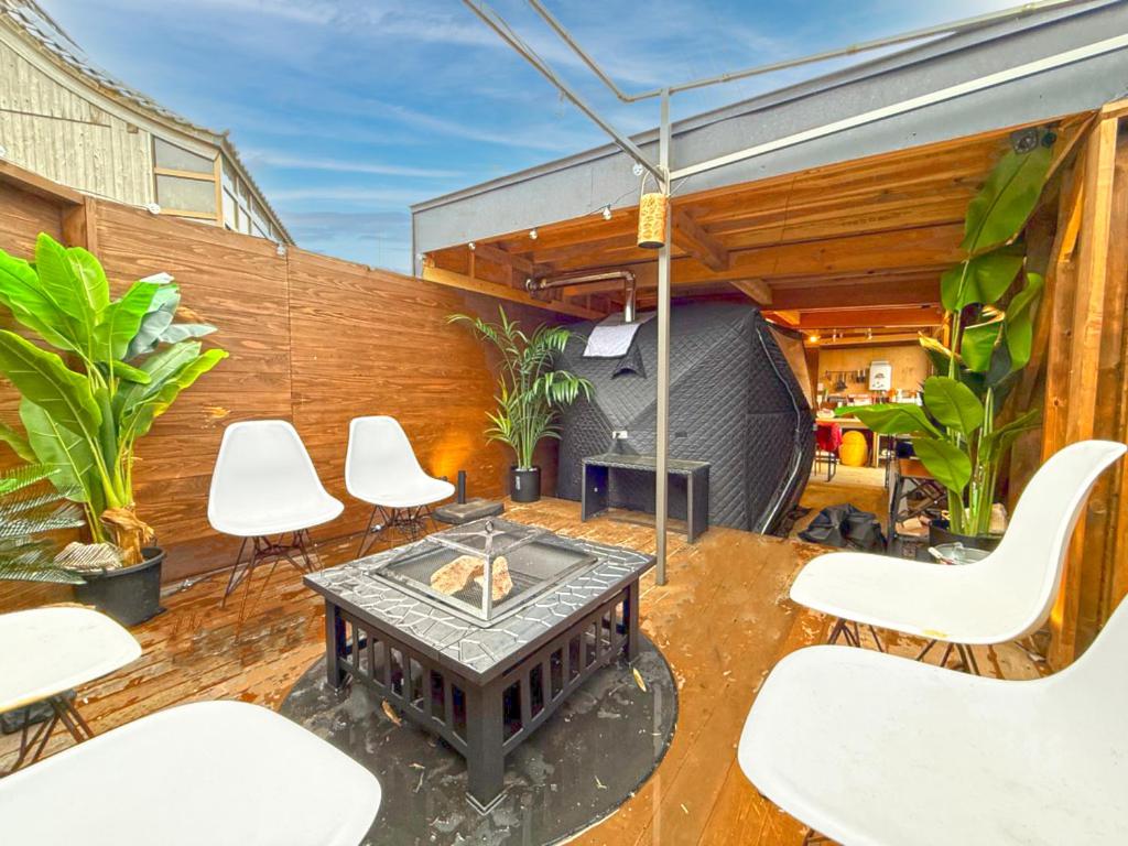 a patio with a table and chairs and a fence at 海宿ニシノヤ in Shioya