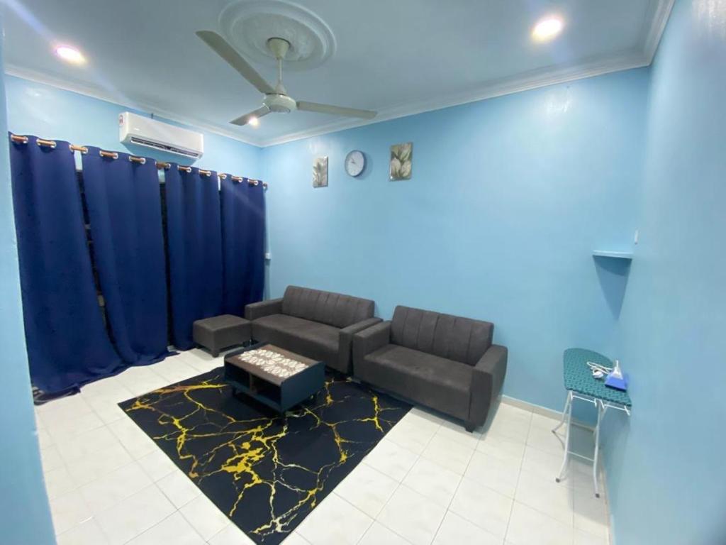 a living room with a couch and a blue wall at VJ Homestay in Jasin