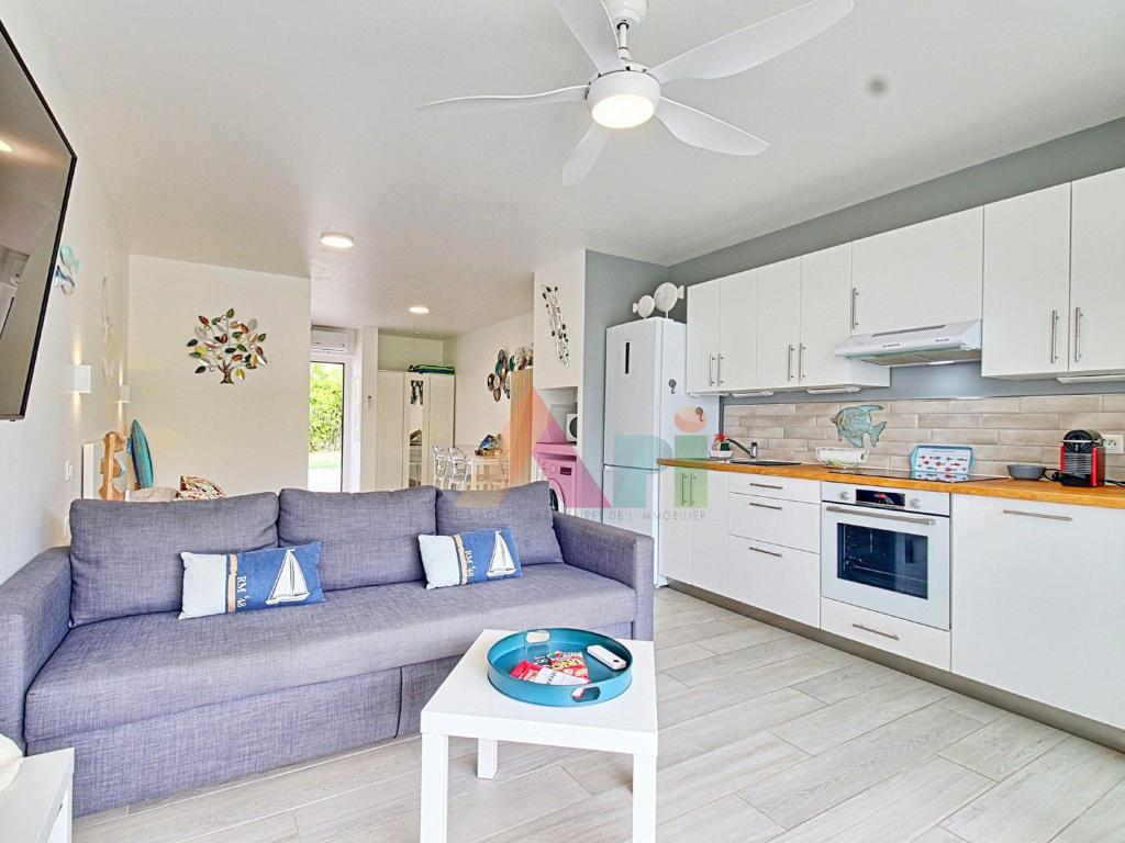 a living room with a purple couch and a kitchen at Studio à Anse Marcel - FR-1-734-86 in Marigot