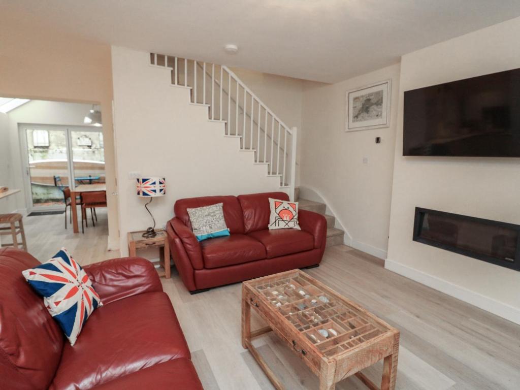 a living room with a red couch and a table at Full Deck in Dartmouth