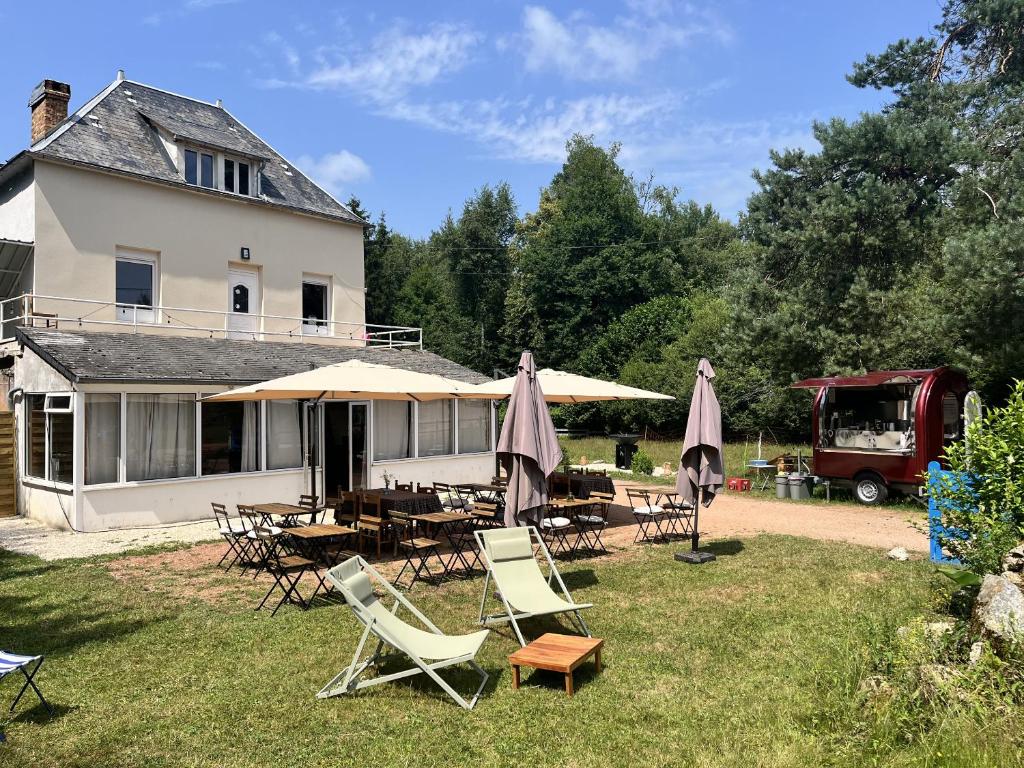 a house with chairs and tables and umbrellas at La Estancia in Montsauche