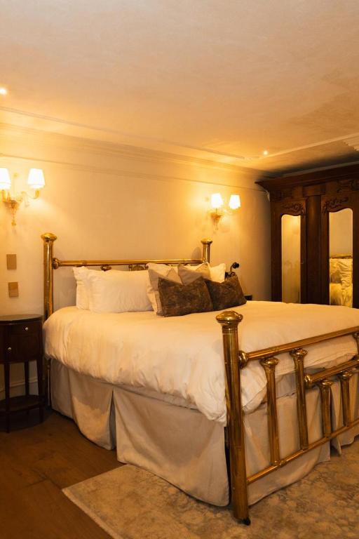 a bedroom with a bed with white sheets and pillows at Mansión Papilio in Mexico City