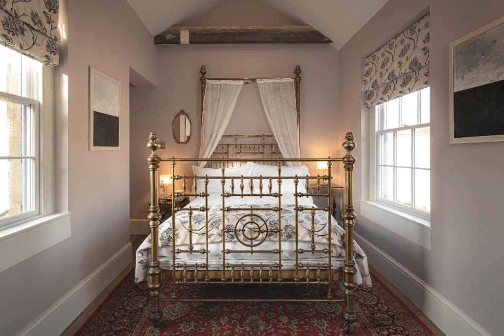 a bedroom with a metal bed in a room with windows at King William in Bath