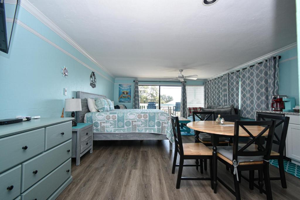 a bedroom with a bed and a table and chairs at Cedar Key Islands Dolphins Cay Condo 230 in Cedar Key