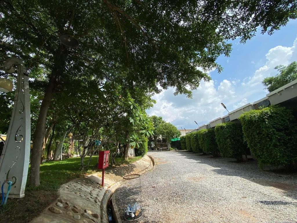 a street with trees on the side of a road at Wang nam yen hill วังน้ำเย็นฮิลล์ in Ban Mai