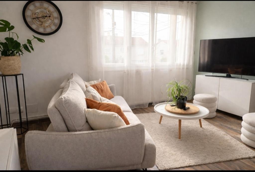 a living room with a couch and a table at Le cosy de Cholet près du PUY DUFOU in Cholet