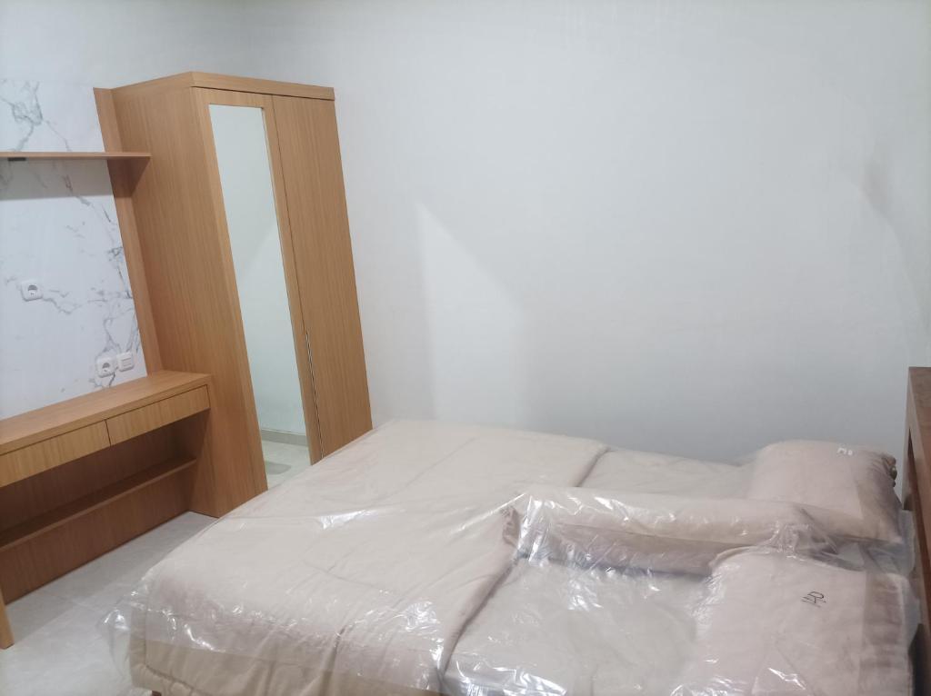 a bedroom with a bed covered in plastic at D & R House Syariah in Jagalan