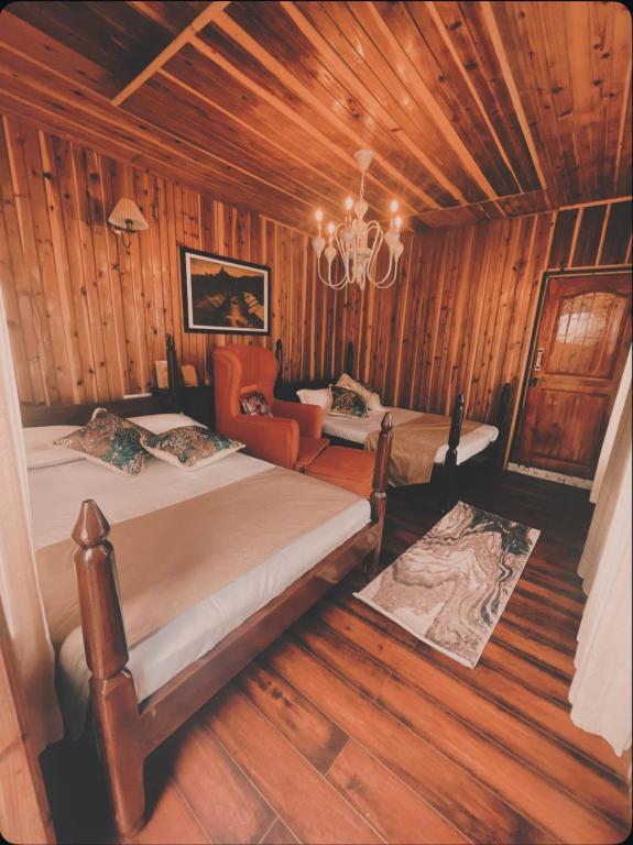 a bedroom with two beds and a chandelier at Lee's Grandma's Will Cottage in Kalimpong