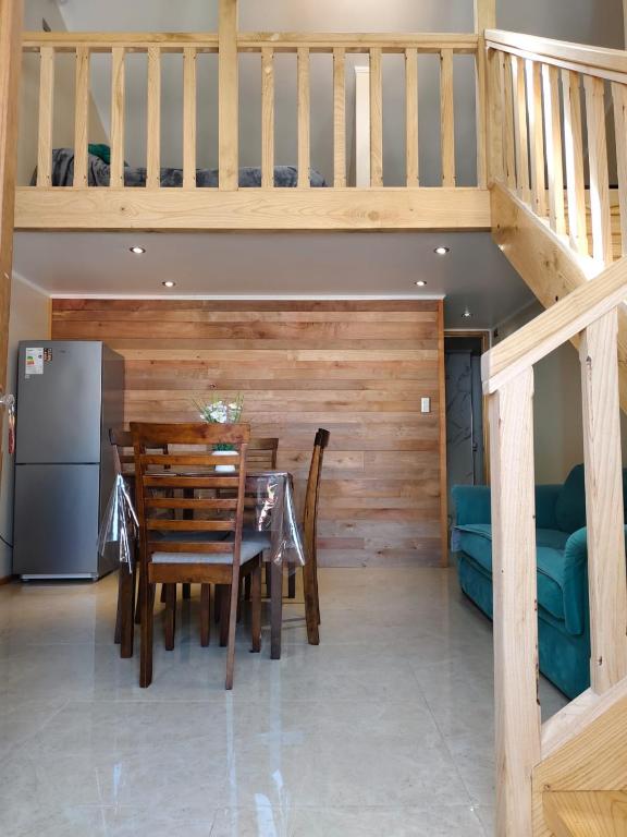 a dining room with a table and a staircase at Loft Volcan Villarrica in Licán Ray