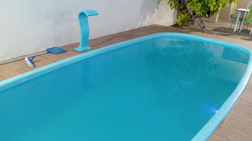 a large blue swimming pool with a blue faucet at Casa com piscina in Marechal Deodoro
