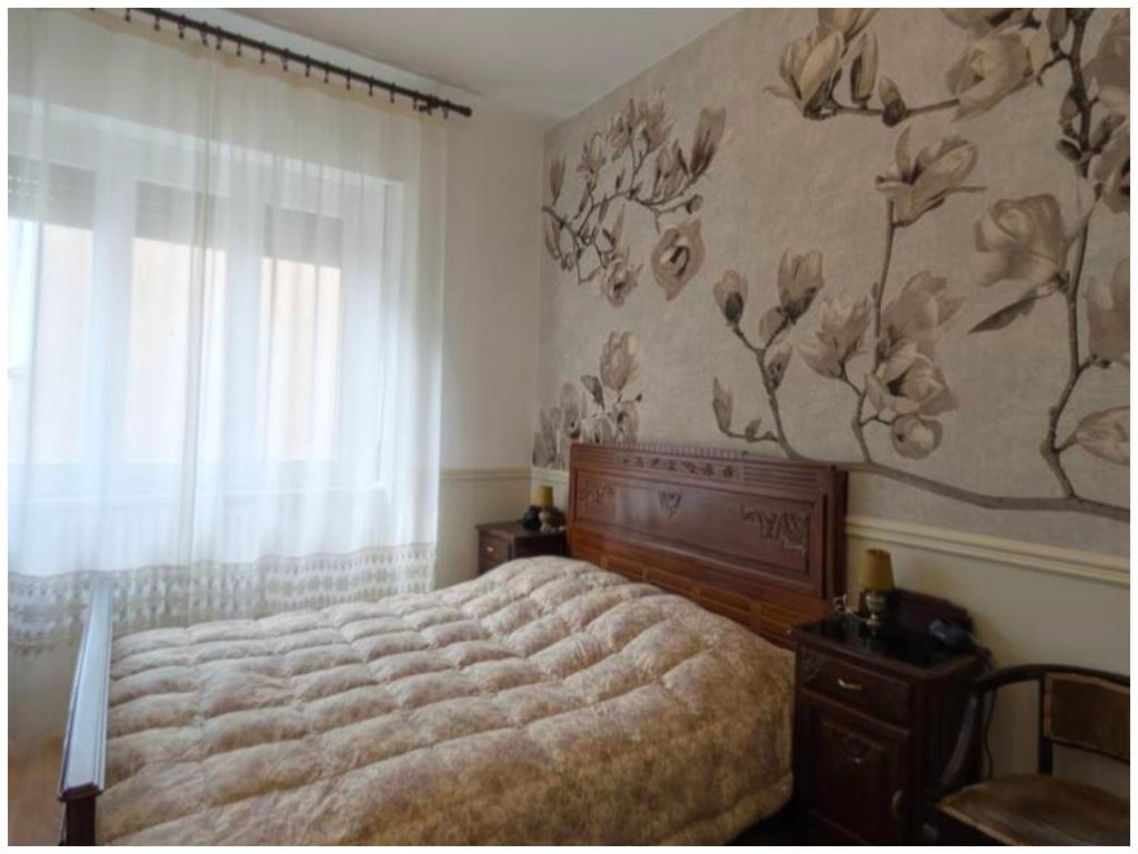 a bedroom with a bed and a flower mural on the wall at AL78 guesthouse in Biella