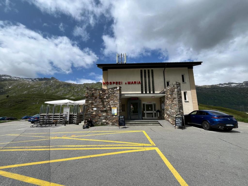 a building with a car parked in a parking lot at Hospezi Santa Maria in Platta