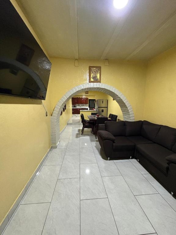 a living room with a couch and an archway at Tequila Jalisco in Tequila