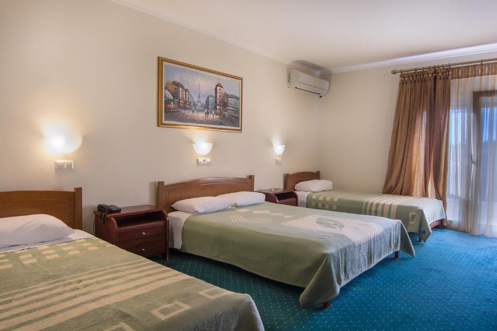 Giường trong phòng chung tại Hotel Alexandros