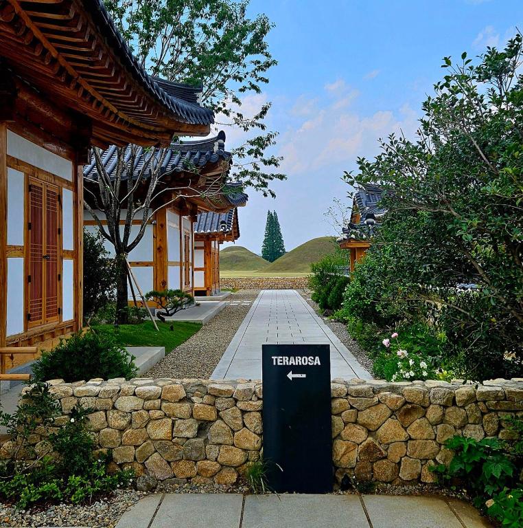 a sign in front of a building with a stone wall at soyeonjae 소연재 in Gyeongju