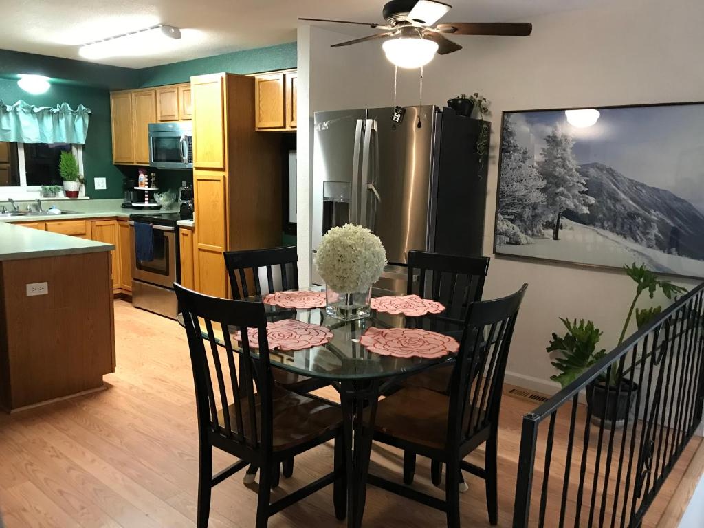 a kitchen with a table with chairs and a refrigerator at 4 Bedroom Vacation House With Pikes Peak view Pet-friendly in Aurora