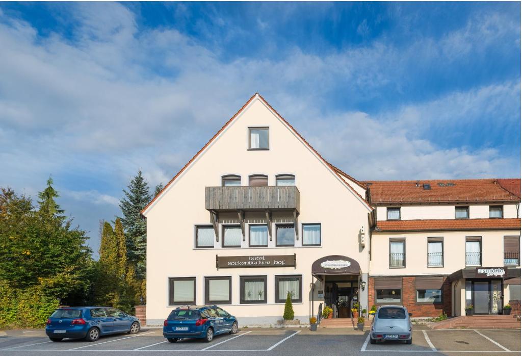 a large white building with cars parked in a parking lot at Hotel Landgasthaus Sockenbacher Hof in Strümpfelbrunn