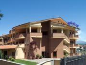 a large apartment building with a fence in front of it at Hotel San Giorgio in Sangano