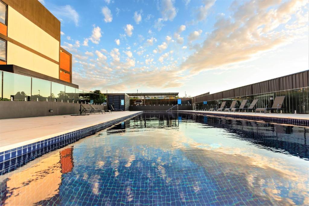 a large swimming pool in front of a building at Mill 7 in Wagga Wagga
