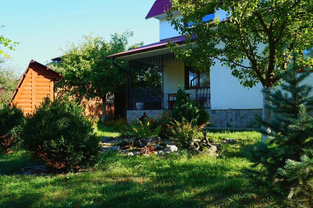 a house with a garden in front of it at Usadba Okhotnichiy Dvor in Yabluniv