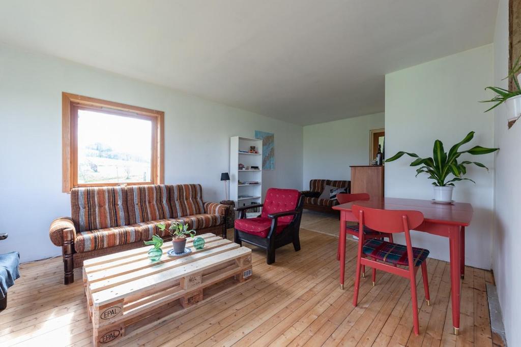 a living room with a red table and chairs at The Greenhouse in Eggum