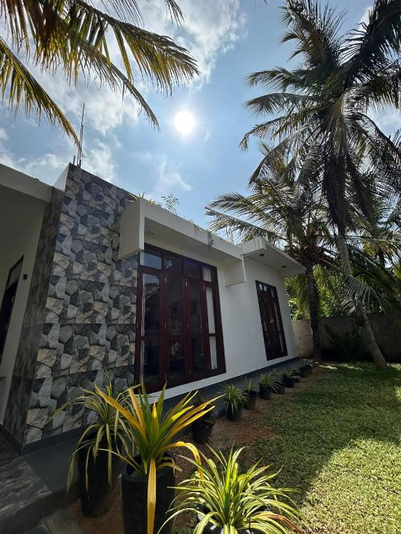 a house with palm trees in front of it at Dasis villa in Hiriketiya