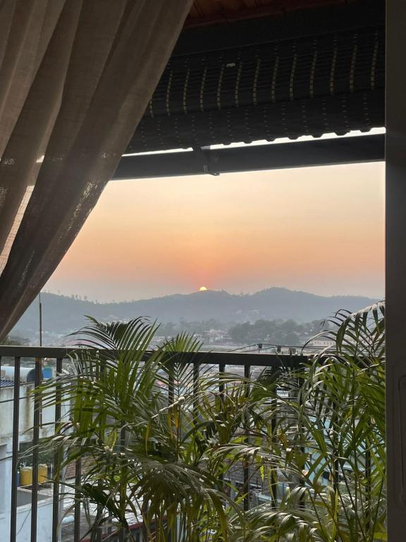 a view of the sunset from the balcony of a building at Shriyaamvitha Homestays in Madikeri