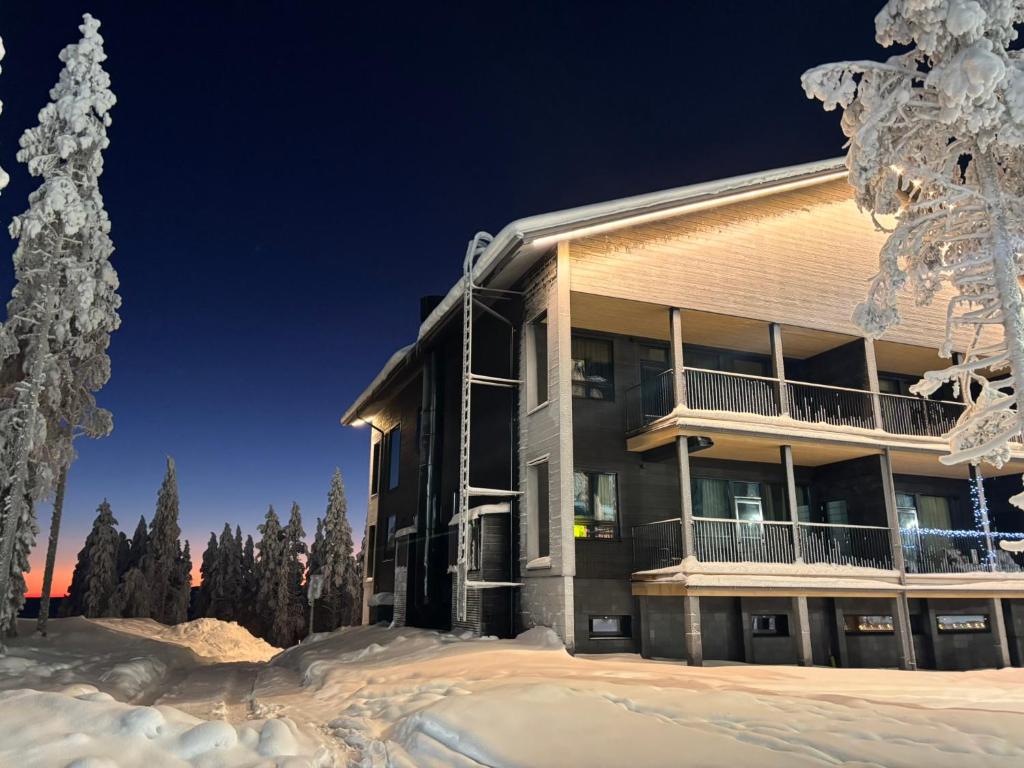 a building in the snow with a tree at Levi Fjällen 6 in Levi