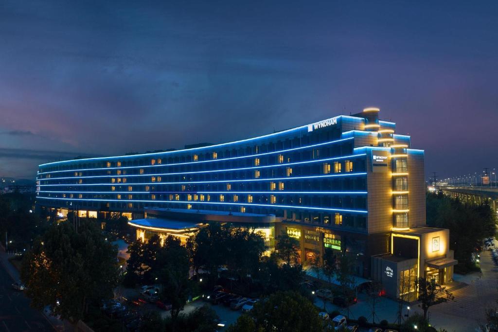 a large building with blue lights on it at night at Wyndham Qingdao in Qingdao