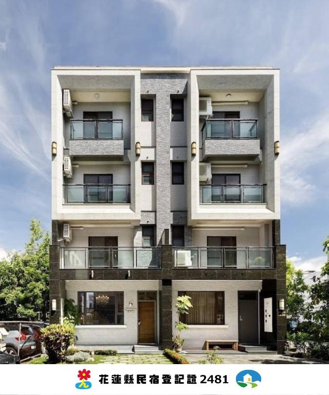 a tall white building with balconies on it at When Happiness Knock your Door in Hualien City