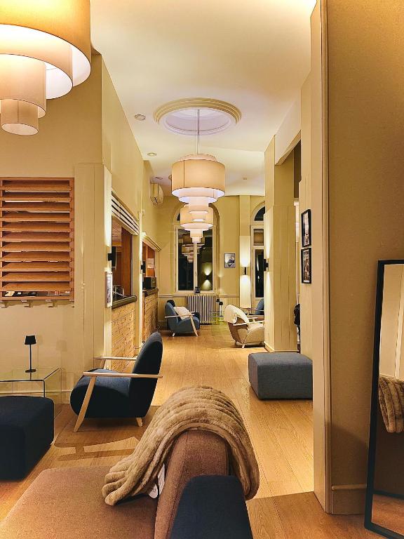 ein Wohnzimmer mit Sofas und Sesseln in der Unterkunft Le Sacca Hôtel restaurant in Cauterets